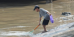 Junge beim Fischen im trüben Saigon-Fluss