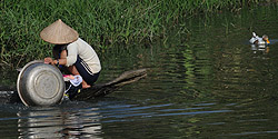 Frau beim Abwasch am Fluss in Liên Sỏn